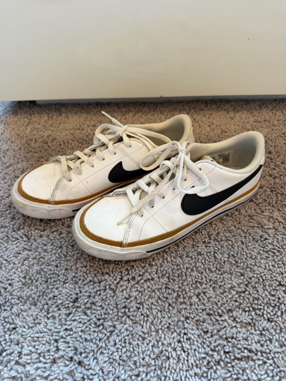 Nike White Low-Top Sneakers with Black Swoosh and Gold Accent